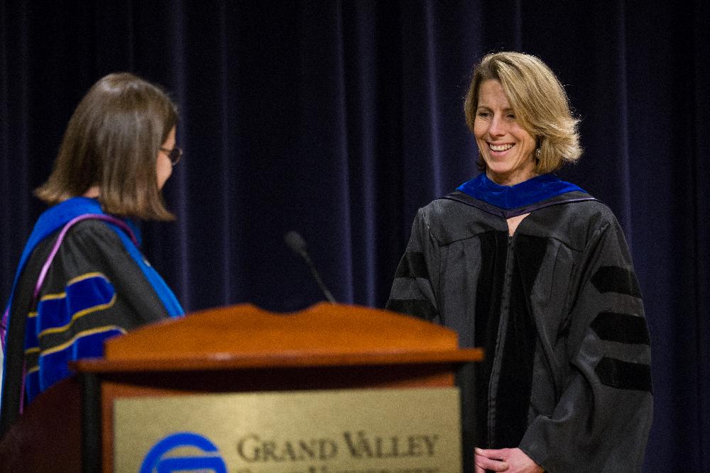 A member of faculty smiles as she receives an award
